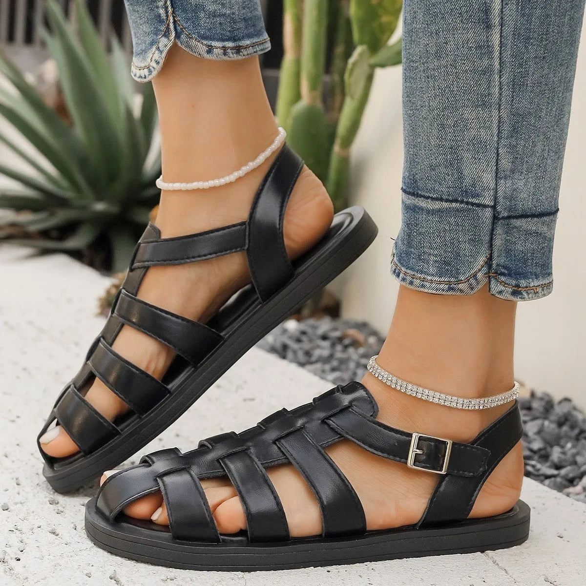 Flat Roman style women's sandals with PU upper and buckle fastening in black