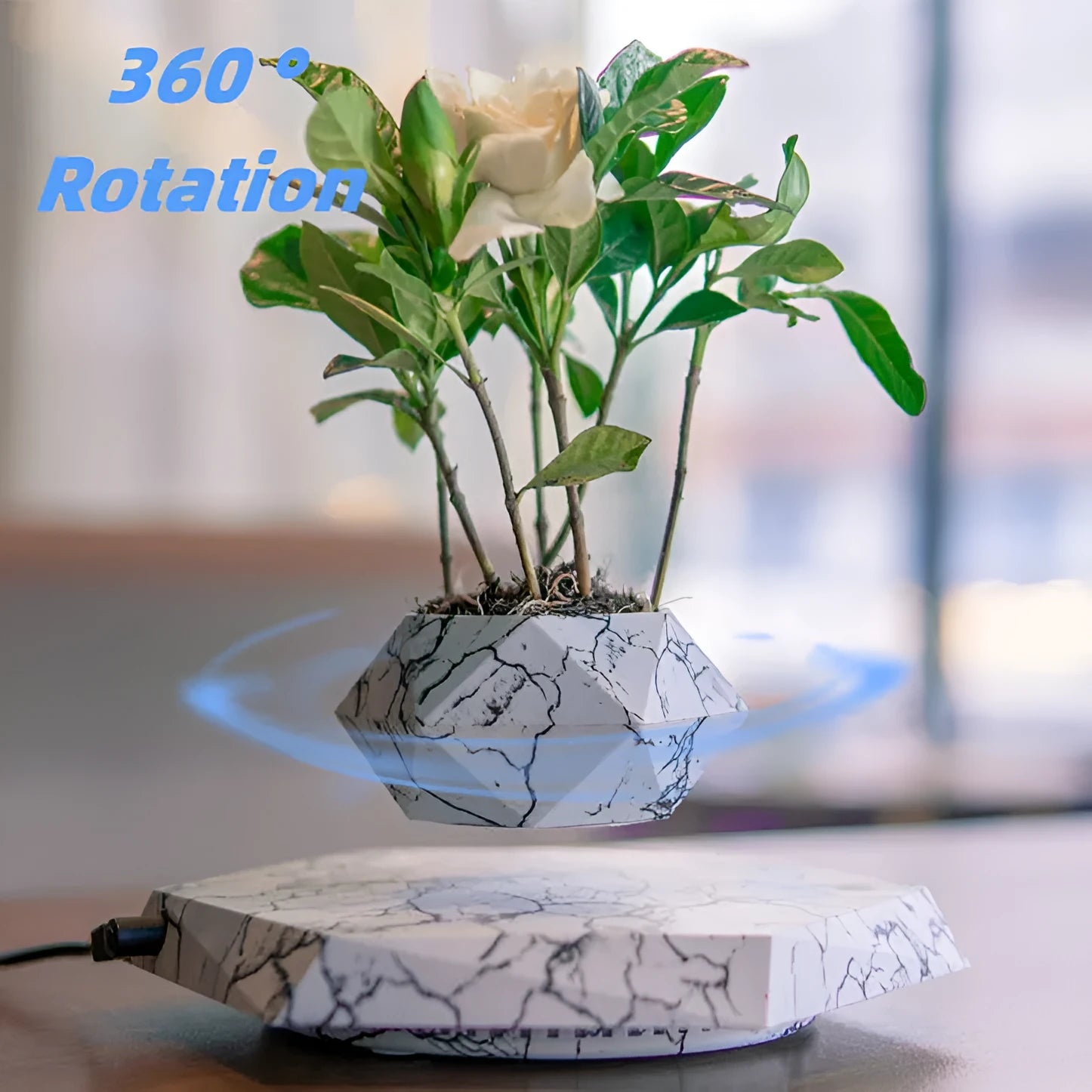 Marble-coloured levitating plant pot floating above magnetic base with small plant rotating