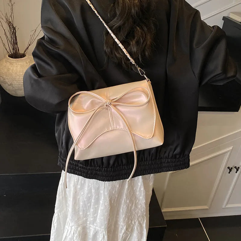 Women's black underarm crossbody bag with horizontal square shape and visible sewing details