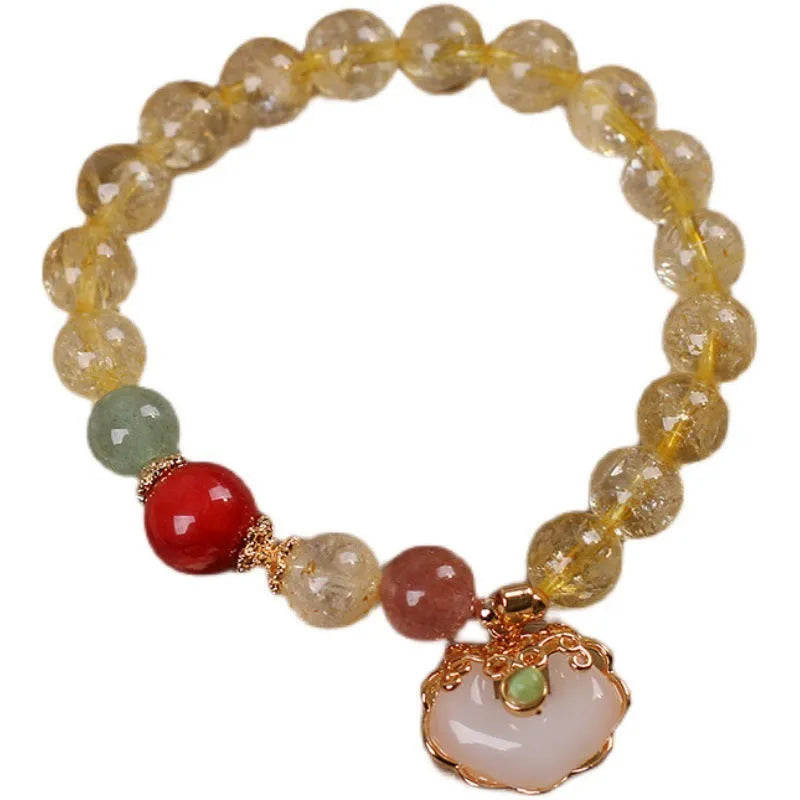 Close-up of a women's alloy bracelet with a yellow citrine jade ruyi pendant.