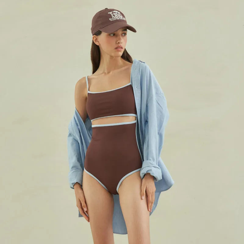 Brown women's one-piece swimsuit with triangle halter neck on a mannequin.