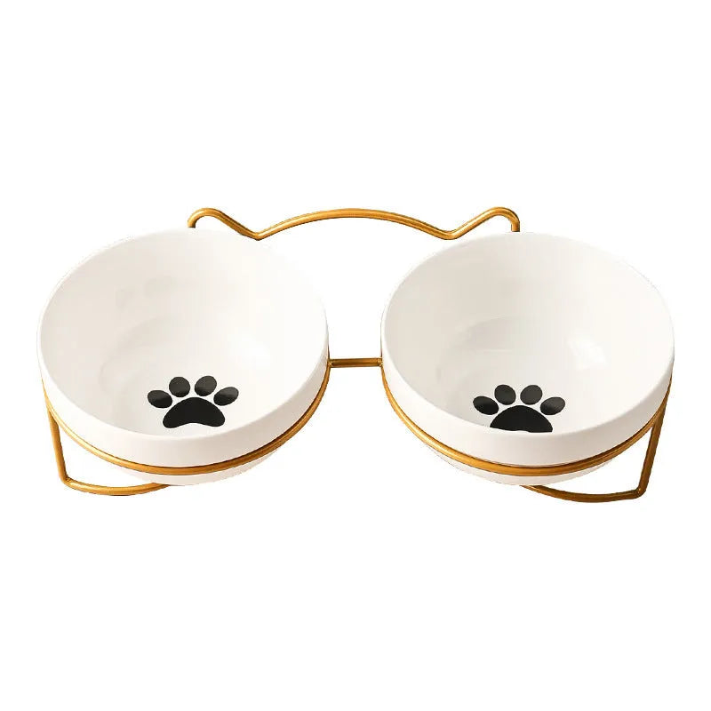 White ceramic cat bowl with paw print design in a black iron cat-ear frame.