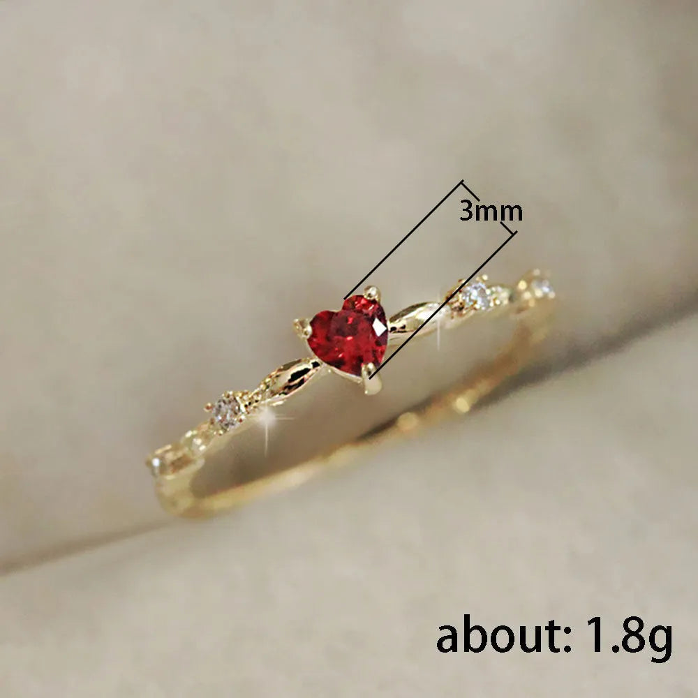 Gold or silver peach heart-shaped ring with clear zircon stones on a copper band.