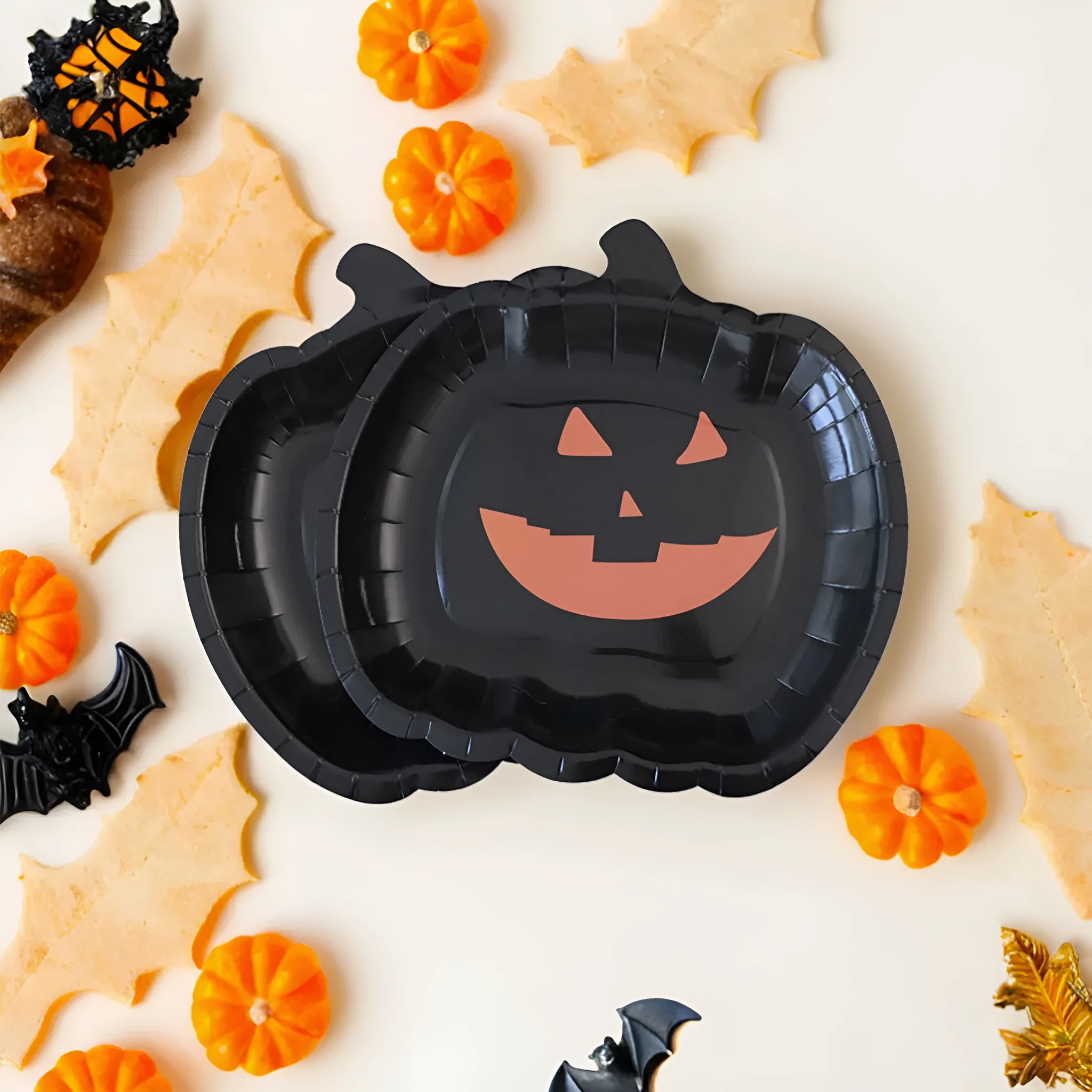 Black Halloween paper plate with pumpkin design, 9 inches in diameter.