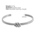 Adjustable stainless steel women's bracelet with gold plating and a double-layer knotted C-shape design.