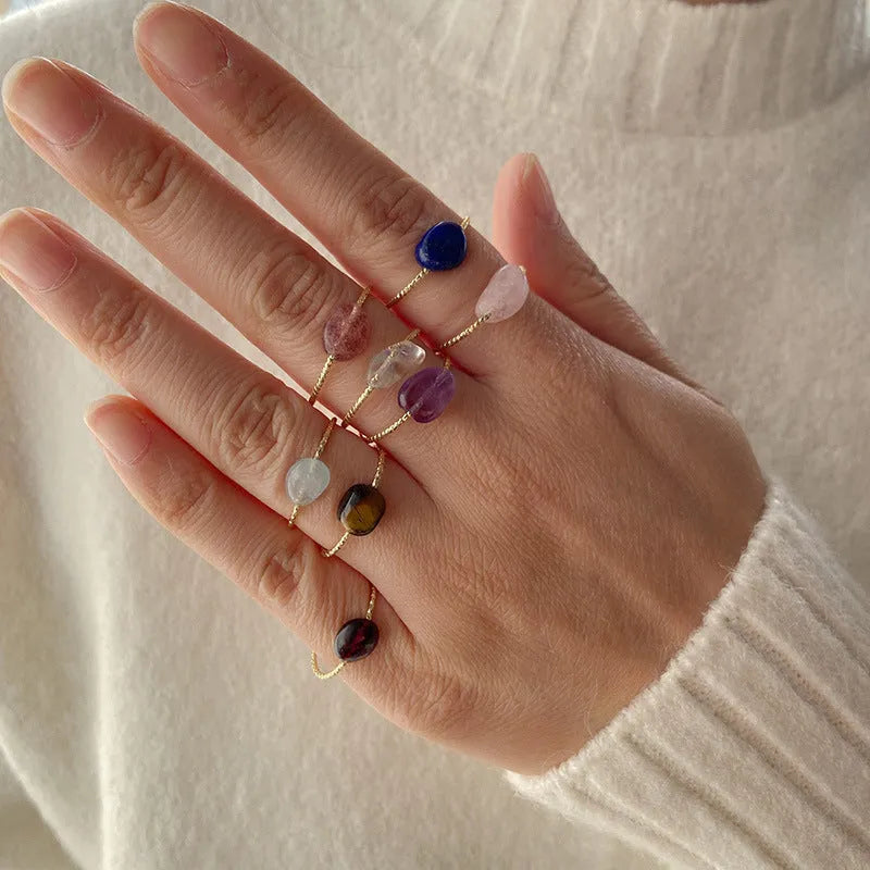 Women's geometric ring with a niche cut in a coloured agate stone on a plain background.