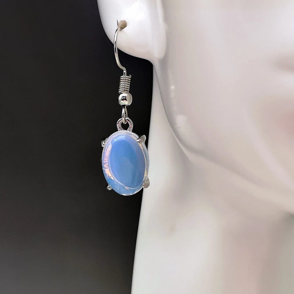 A pair of retro drop-shaped earrings with an opal moonstone colour and elliptical decorative elements.