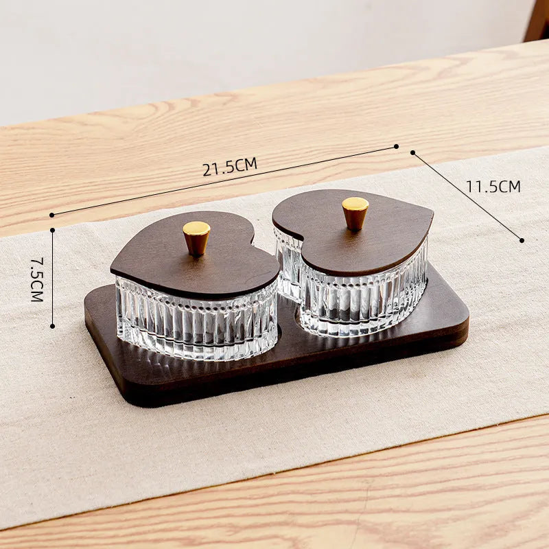 Glass serving platter with heart-shaped transparent lids in a 4-grid configuration on a table.