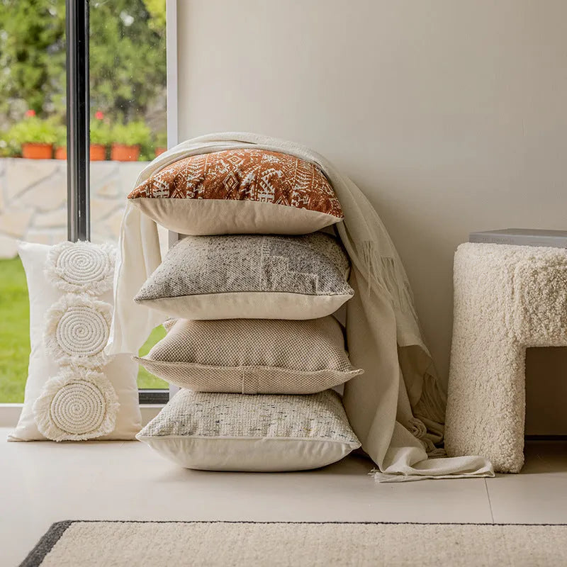 A square coreless decorative sofa cushion with an abstract geometric pattern in red and brown colours.