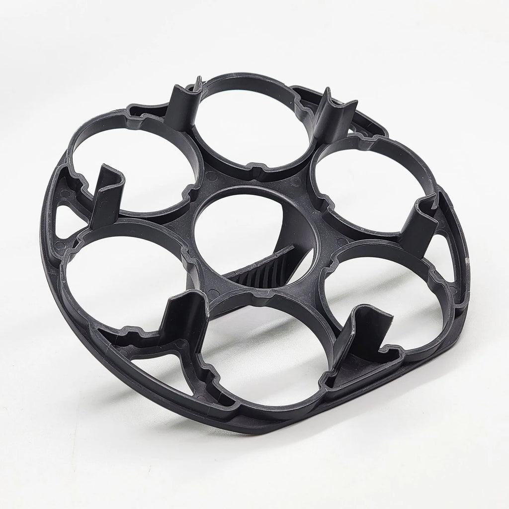 Black plastic egg holder rack for a cooking machine on a kitchen countertop.