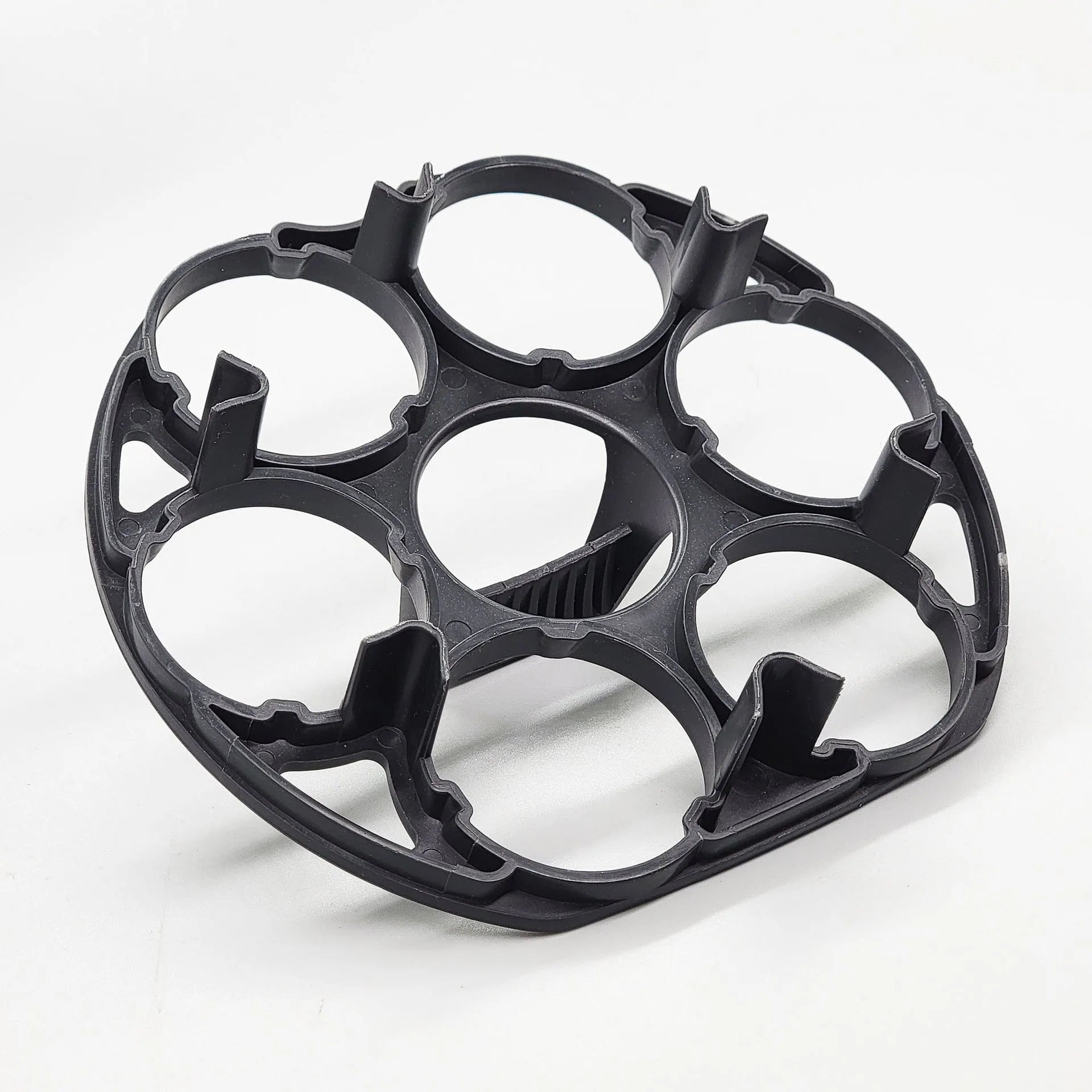 Black plastic egg holder rack for a cooking machine on a kitchen countertop.