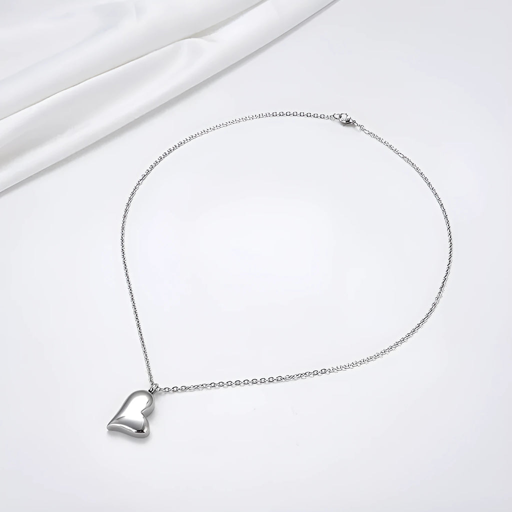 Silver curved peach heart pendant necklace on a stainless steel chain with an extension.