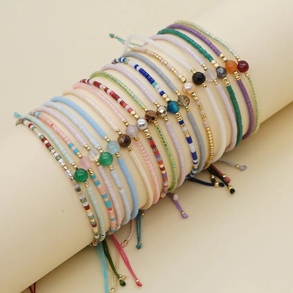 Handmade colourful beaded bracelet with geometric stone and glass beads on a wrist