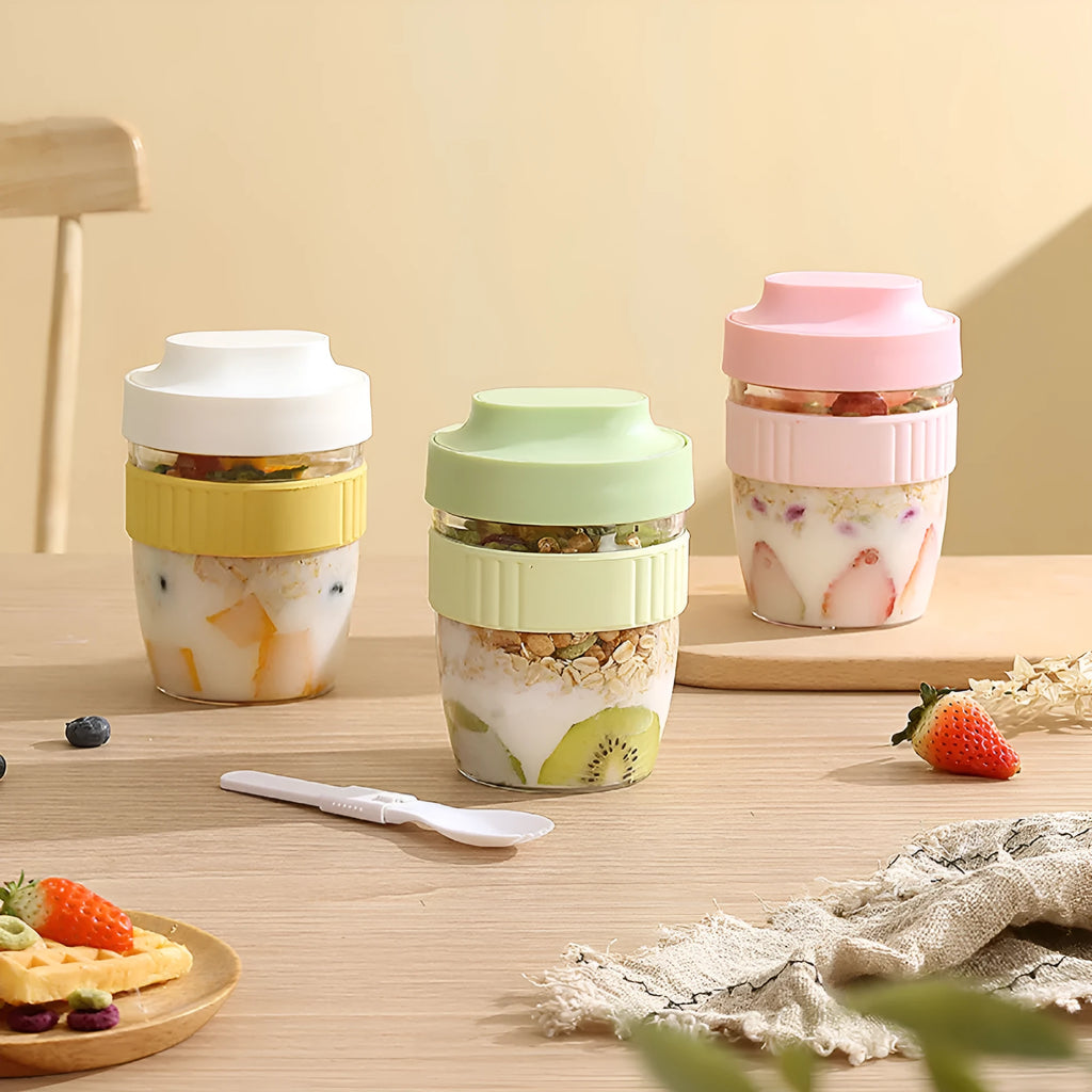 Green plastic salad cup with clear lid and white spoon on a table