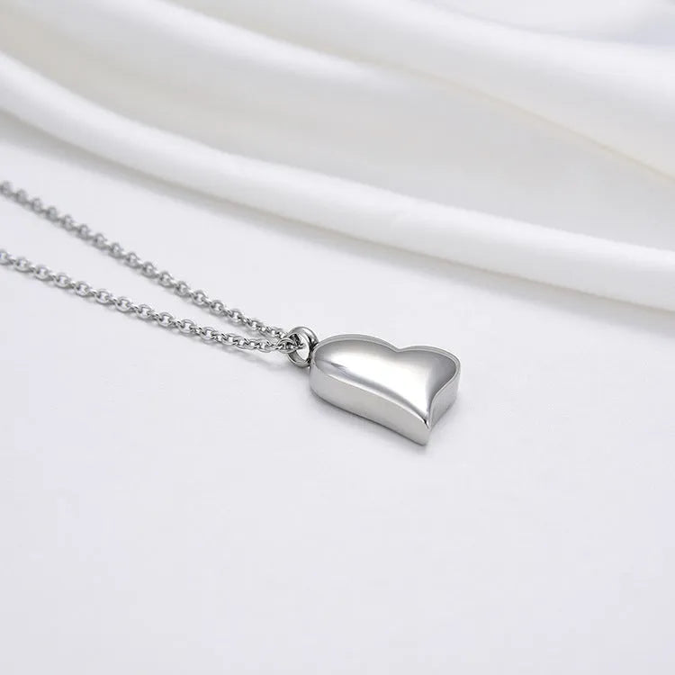 Silver curved peach heart pendant necklace on a stainless steel chain with an extension.