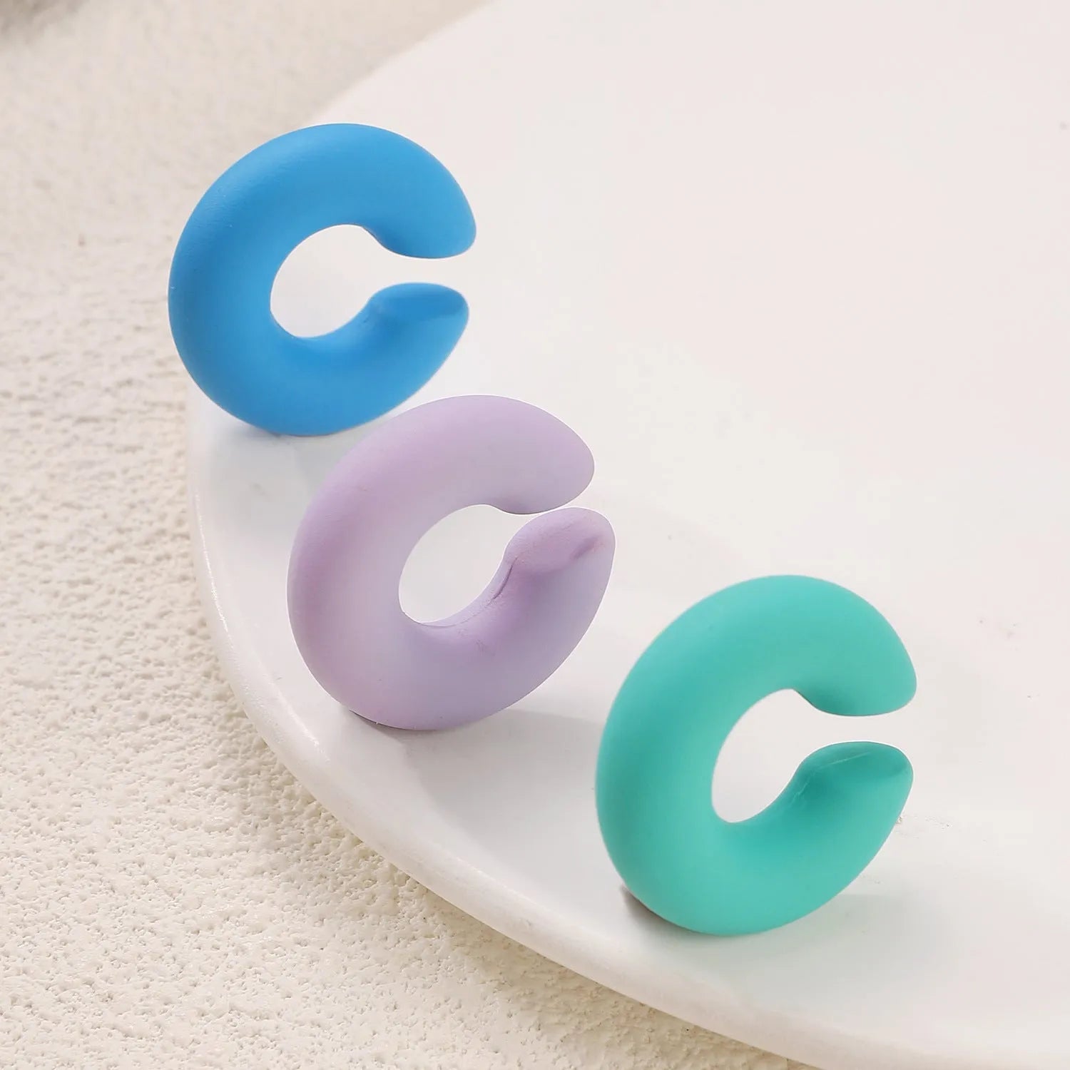 Round C-shaped geometric clip-on earrings with matte finish in various candy colours