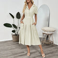 Light green women's lapel collar shirt dress with waist tie and side pockets on a dress form.