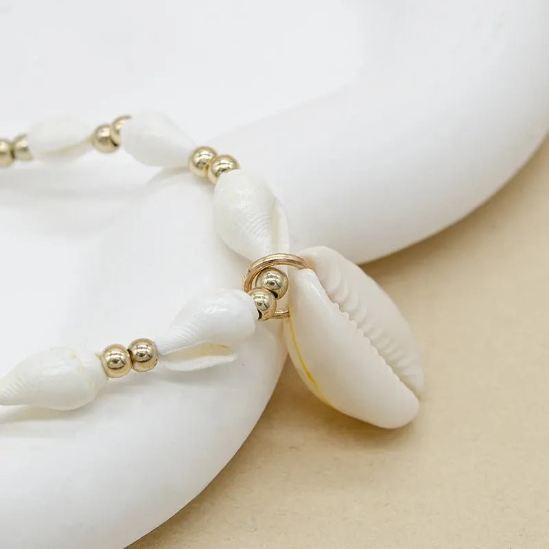 White conch shell bead necklace with a mother-of-pearl pendant on a regular chain.