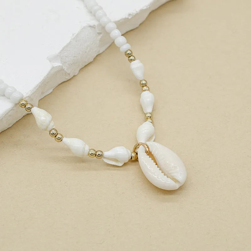 White conch shell bead necklace with a mother-of-pearl pendant on a regular chain.