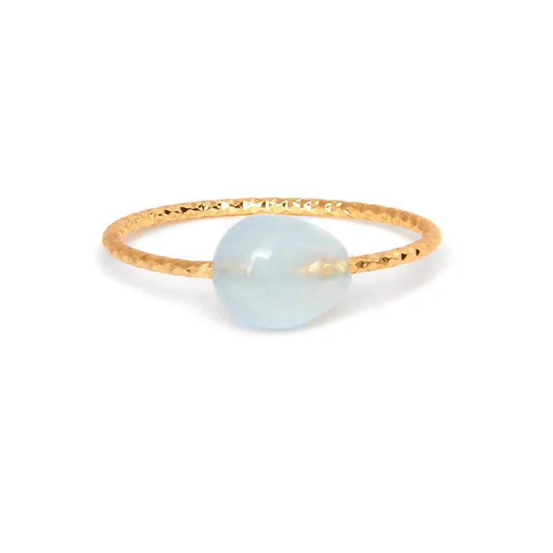 Geometric silver-toned ring setting with a central oval of blue and white banded agate stone on a woman's hand.