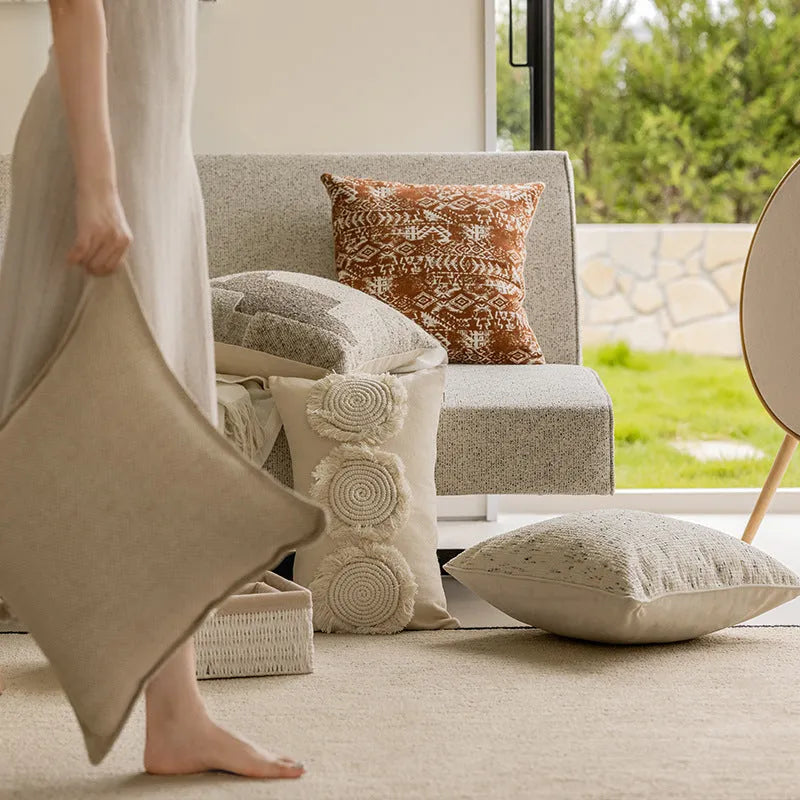 A square coreless decorative sofa cushion with an abstract geometric pattern in red and brown colours.
