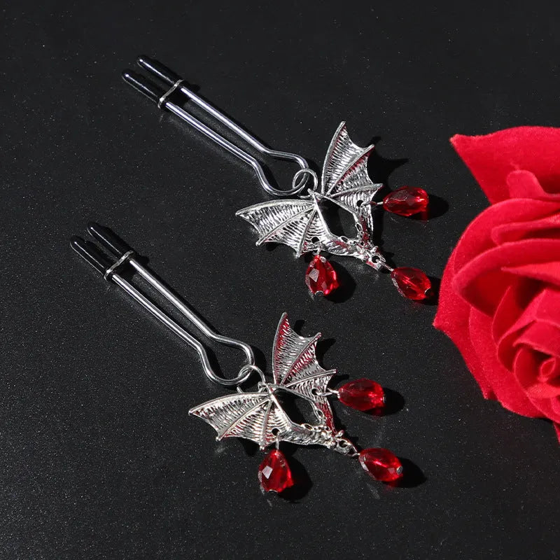Silver diamond bat design nipple clamp with ruby accents and adjustable tension mechanism