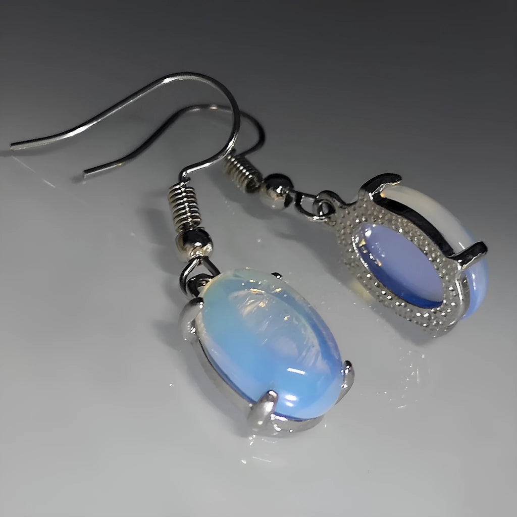 A pair of retro drop-shaped earrings with an opal moonstone colour and elliptical decorative elements.