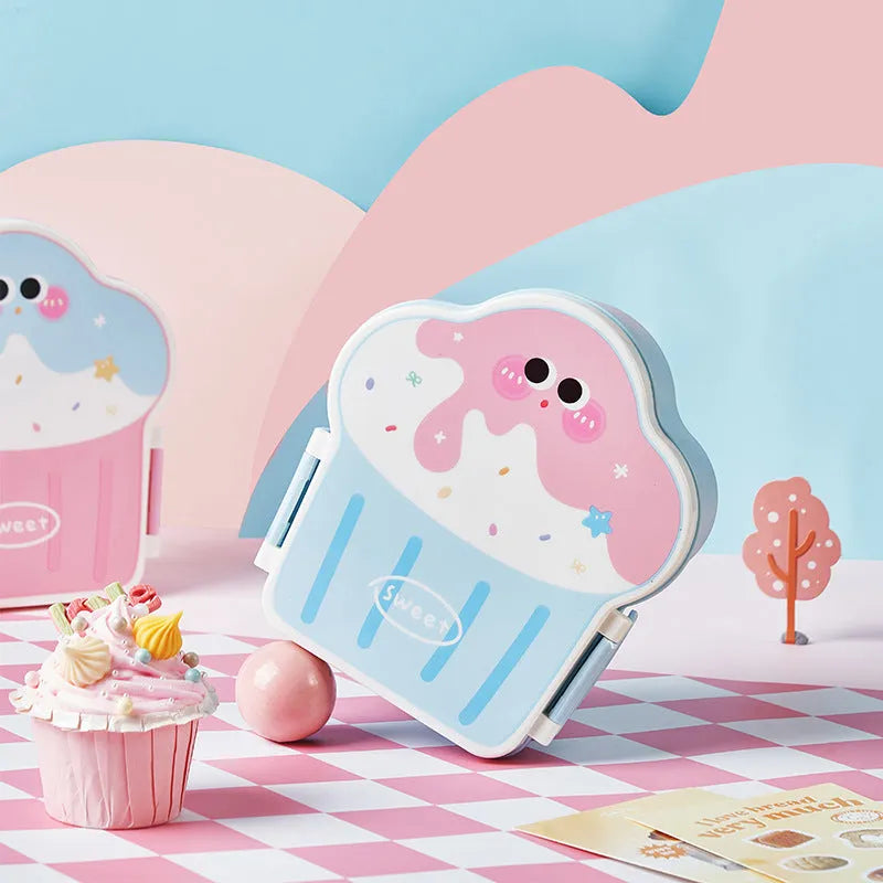 Blue and pink creative ice cream shaped plastic lunch box with spoon and fork set on a table.