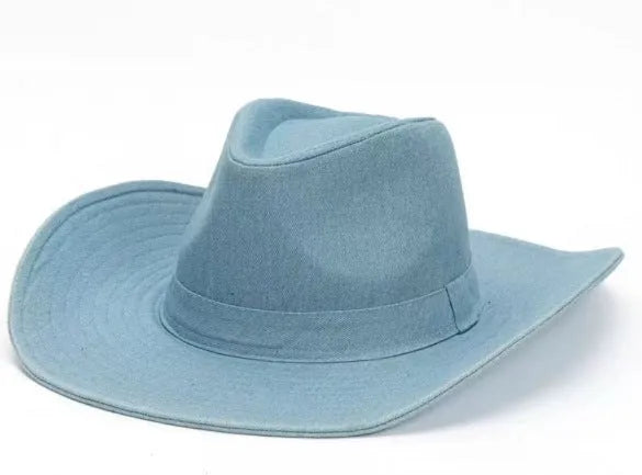 Brown leather velvet curved edge Western cowboy hat with a conical crown on a wooden surface.