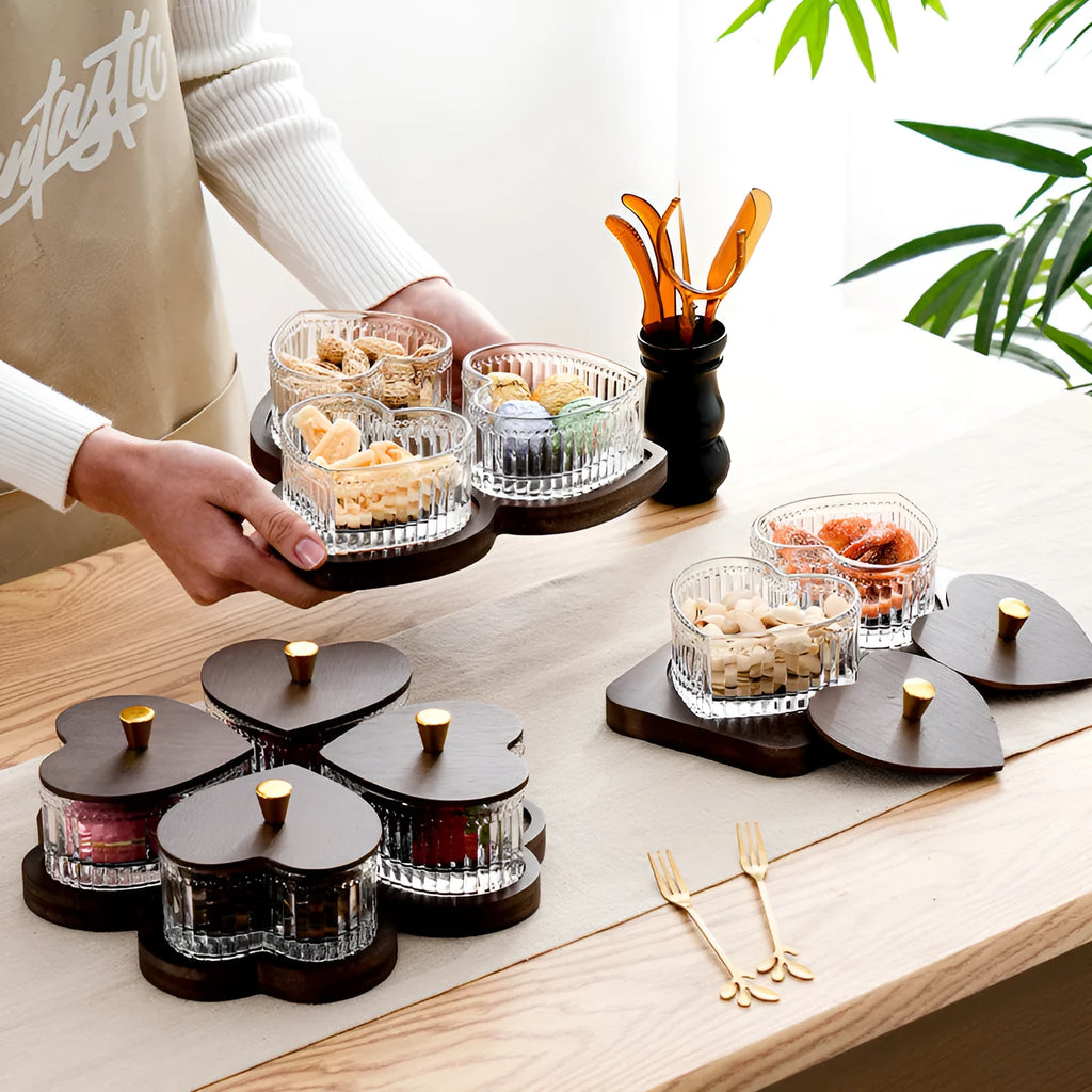 Glass serving platter with heart-shaped transparent lids in a 4-grid configuration on a table.