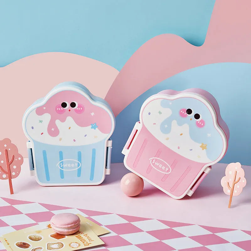 Blue and pink creative ice cream shaped plastic lunch box with spoon and fork set on a table.