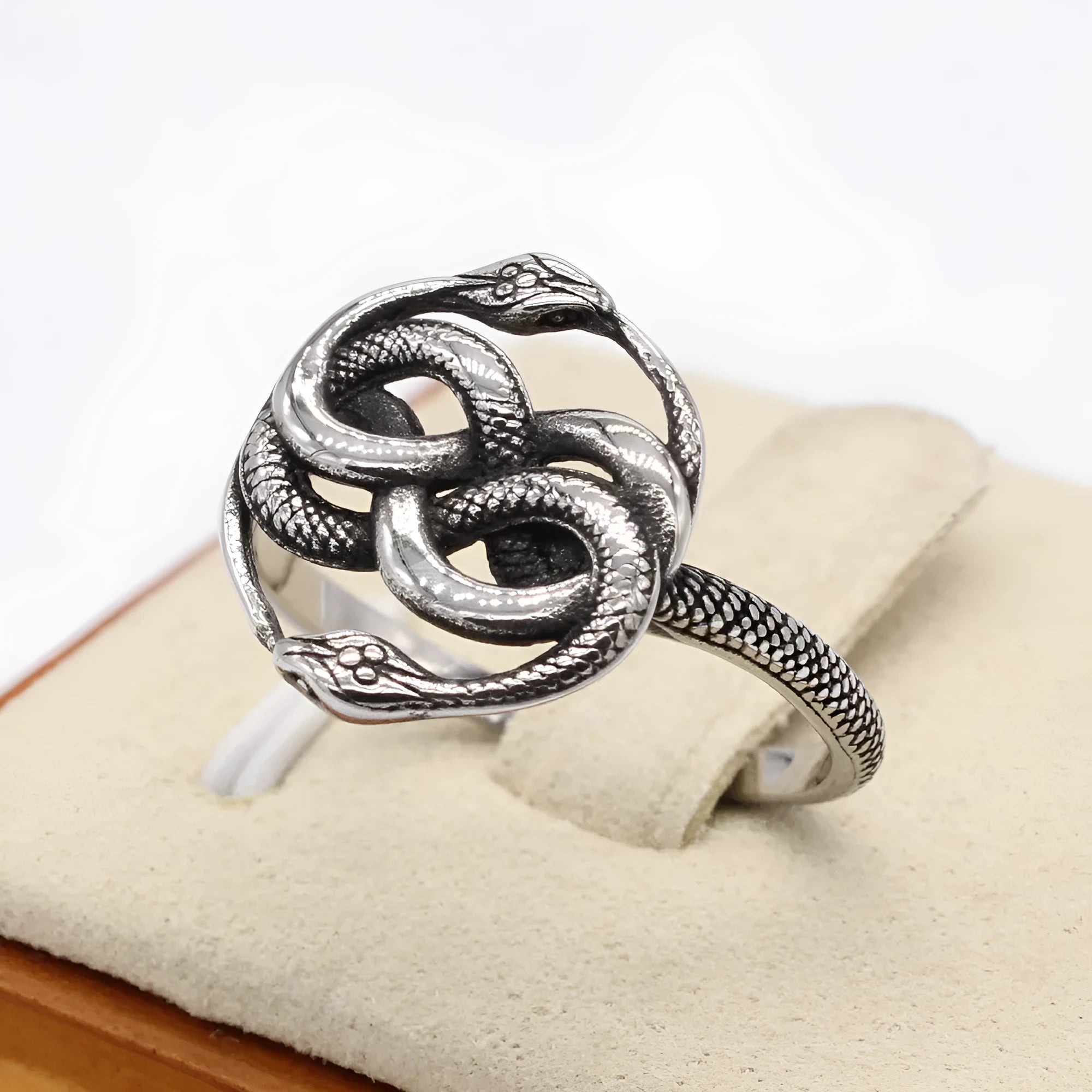 A titanium steel double snake ring in a steel colour on a neutral background.
