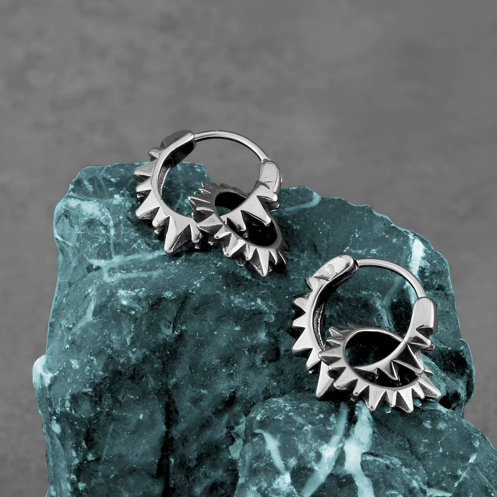 Polished steel round ring earrings with retro styling on stainless steel background