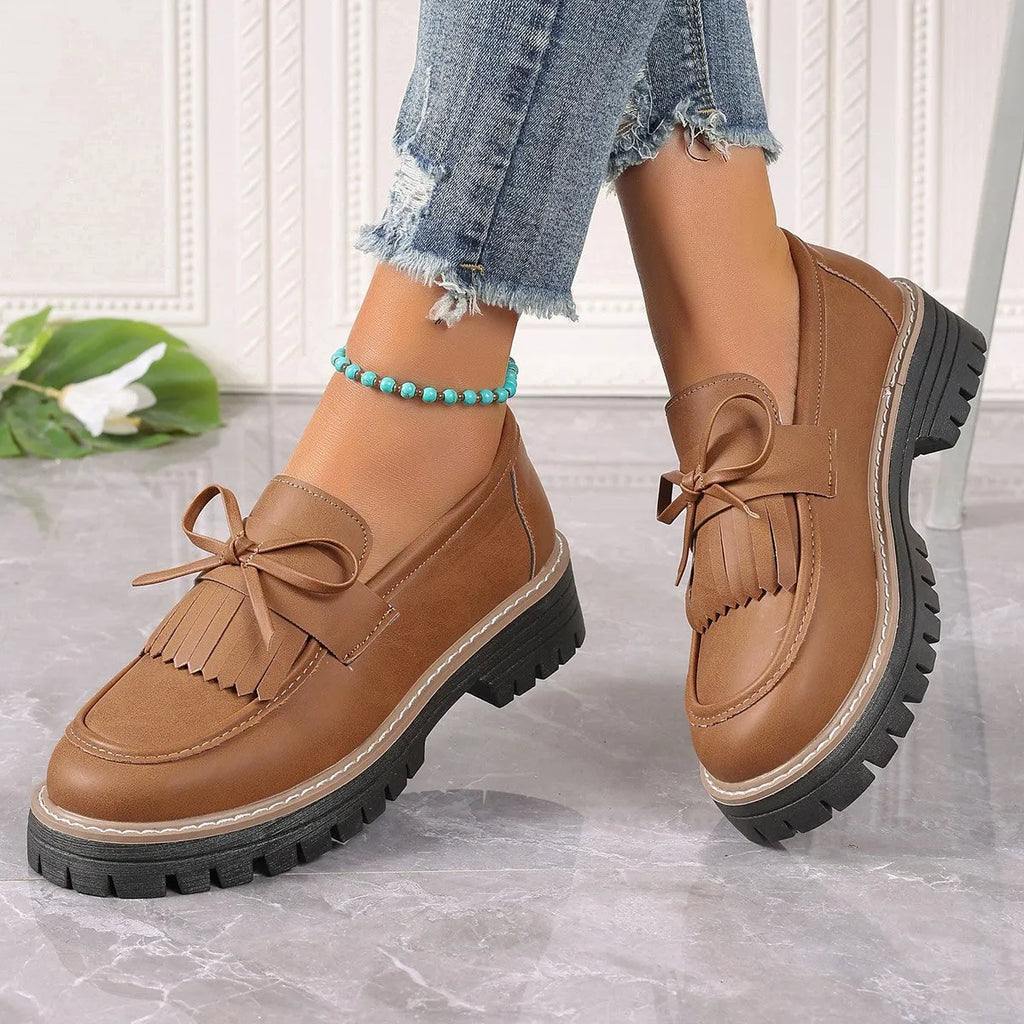 Black plus size women's loafers with a tassel and bowknot on a low-top PU upper.