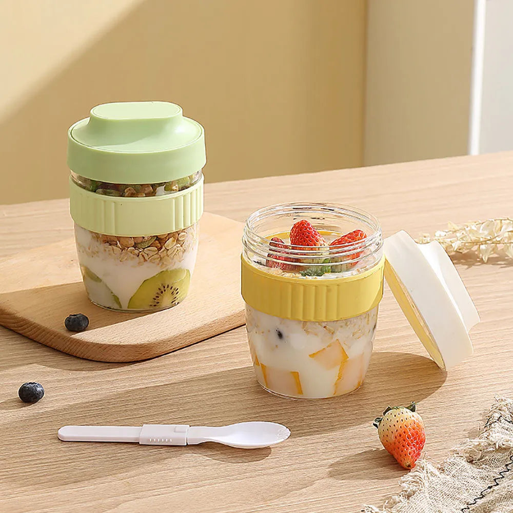 Green plastic salad cup with clear lid and white spoon on a table