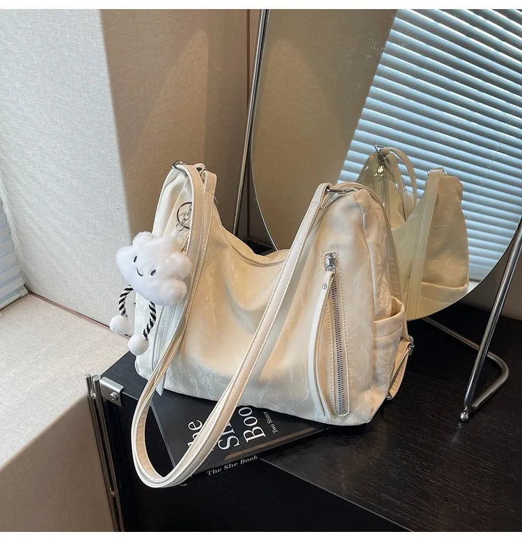 Women's soft PU backpack in neutral colours with pendant accessory