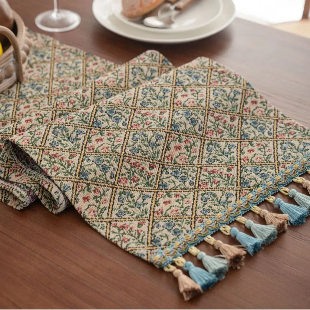Dark blue striped jacquard table runner with tassel trim laid on a wooden table