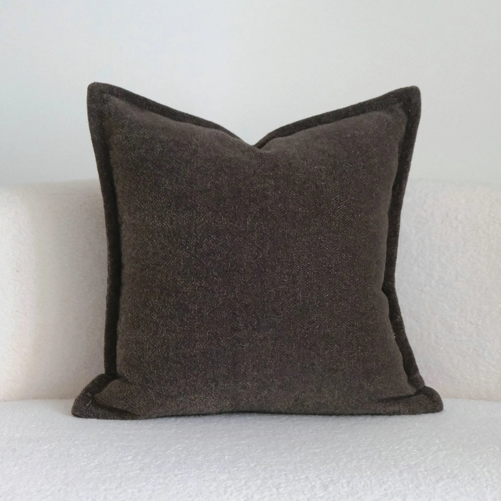Coffee brown striped mid-century modern lumbar cushion on a grey sofa.