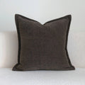Coffee brown striped mid-century modern lumbar cushion on a grey sofa.