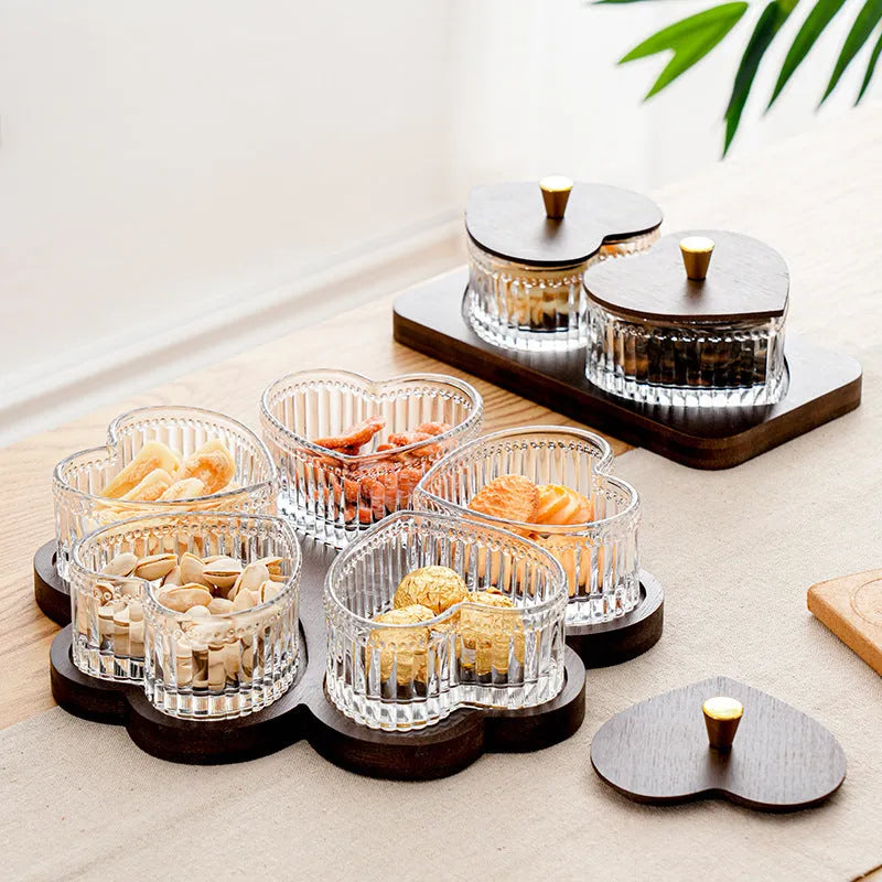 Glass serving platter with heart-shaped transparent lids in a 4-grid configuration on a table.