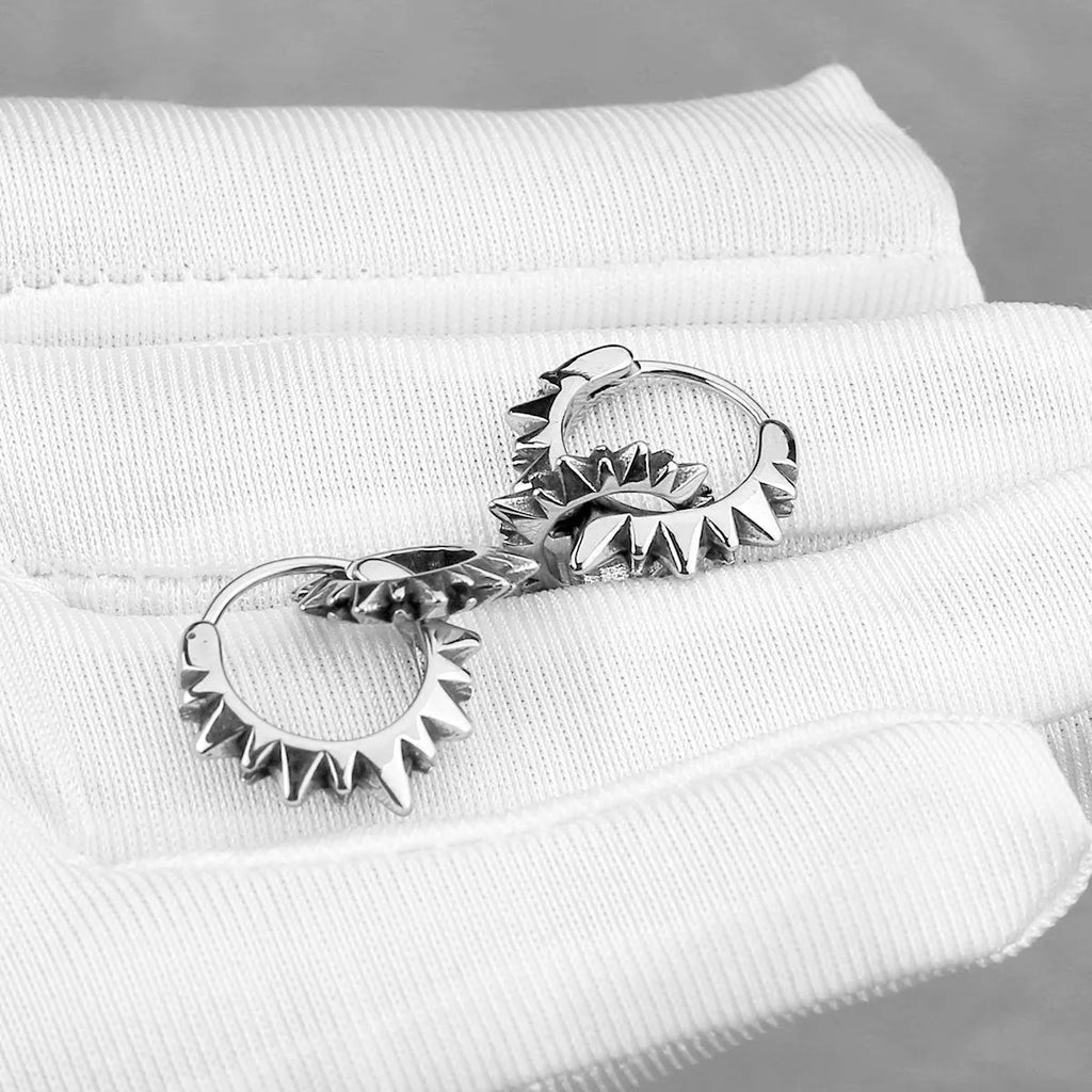 Polished steel round ring earrings with retro styling on stainless steel background