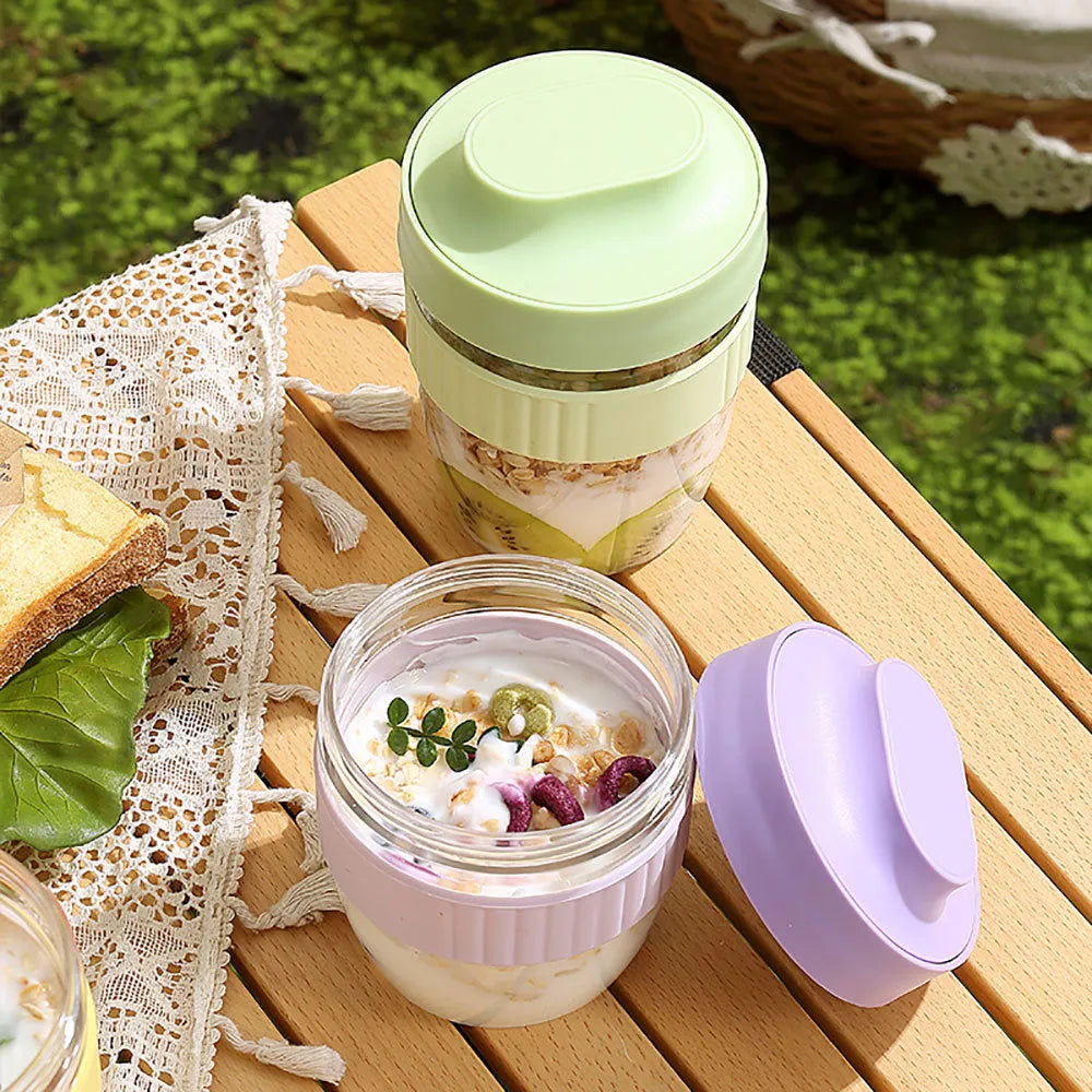 Green plastic salad cup with clear lid and white spoon on a table