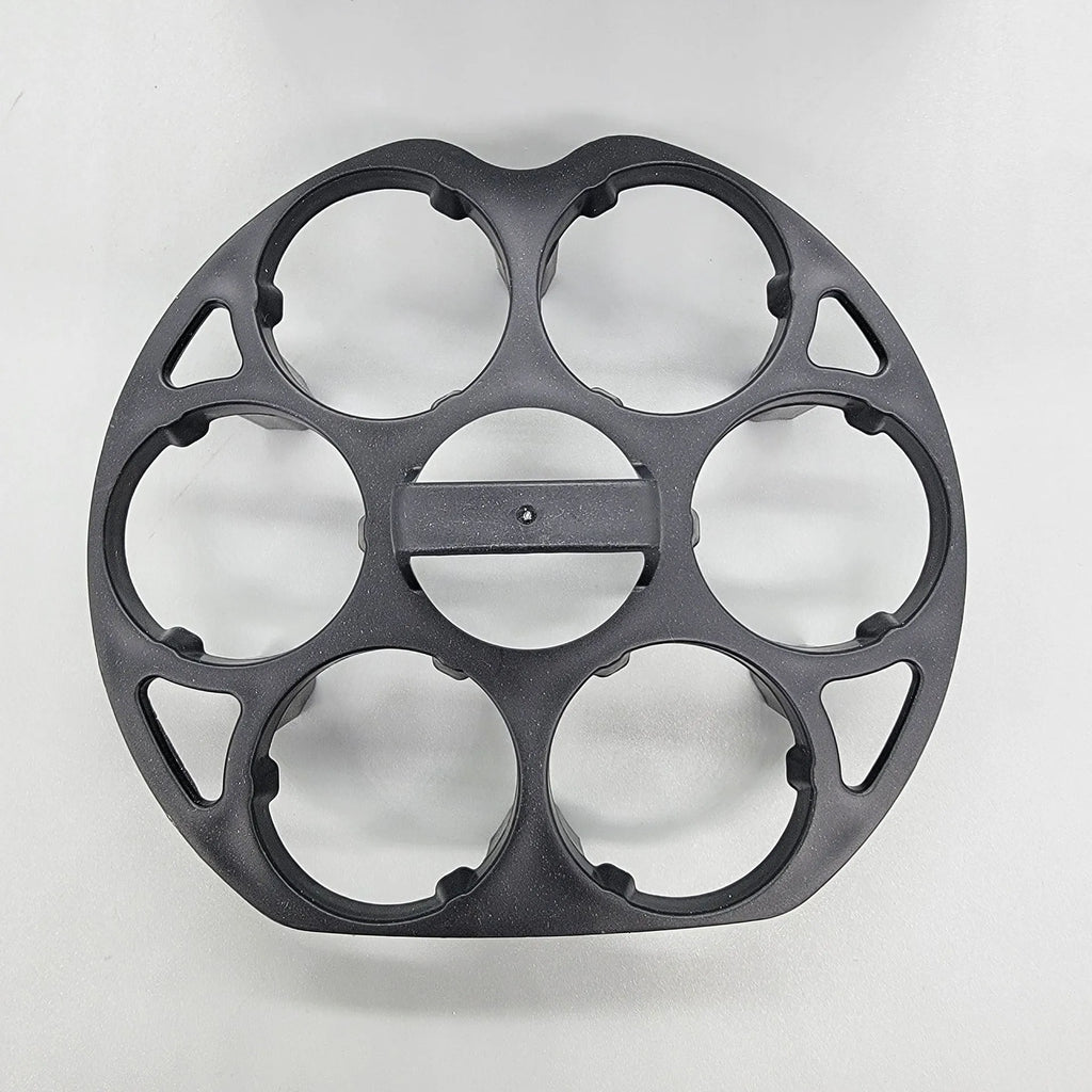 Black plastic egg holder rack for a cooking machine on a kitchen countertop.