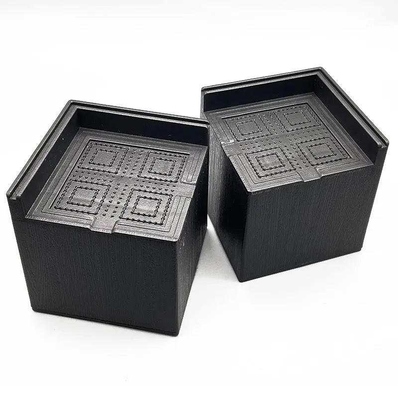 Four black plastic furniture foot mats for bed and sofa height adjustment