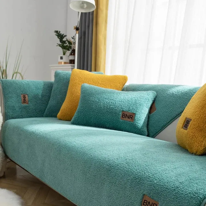 Lambswool sofa cover in blue on a grey sofa, showing simple solid colour and cloth liner style.