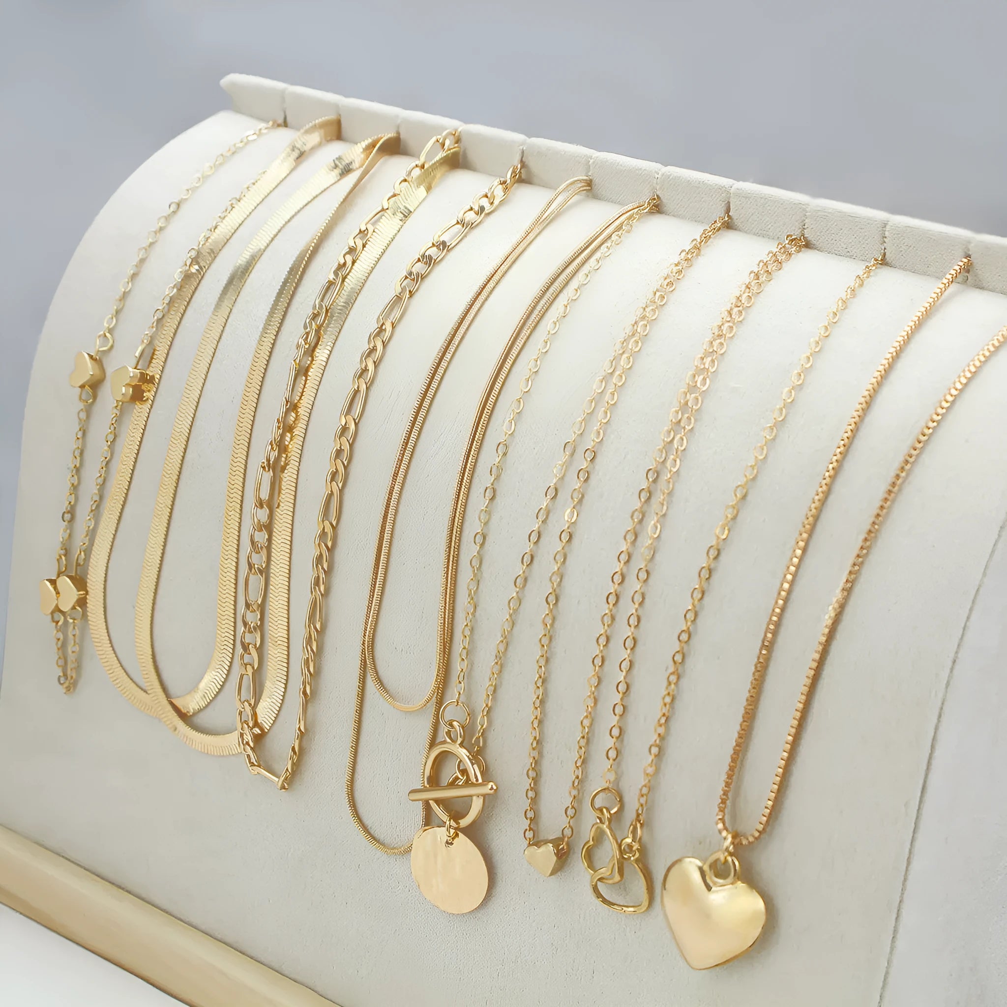 Set of ten gold-coloured women's necklaces with snake bones chains and alloy pendants.