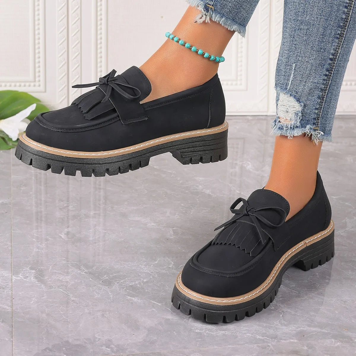 Black plus size women's loafers with a tassel and bowknot on a low-top PU upper.