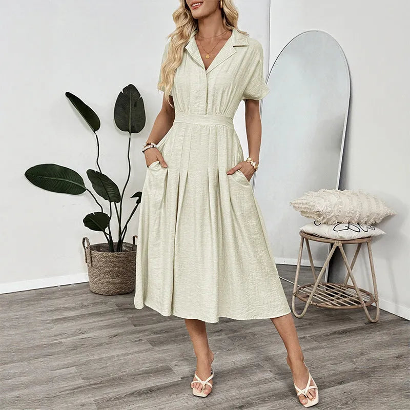 Light green women's lapel collar shirt dress with waist tie and side pockets on a dress form.