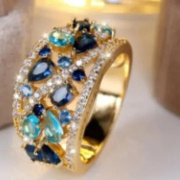 Women's round hollow copper fashion ring with a choice of gemstone colours, shown in gold and platinum finishes.