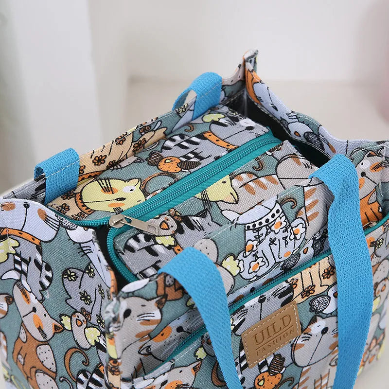 Women's square canvas handbag with floral and animal prints, showing aluminium hardware.
